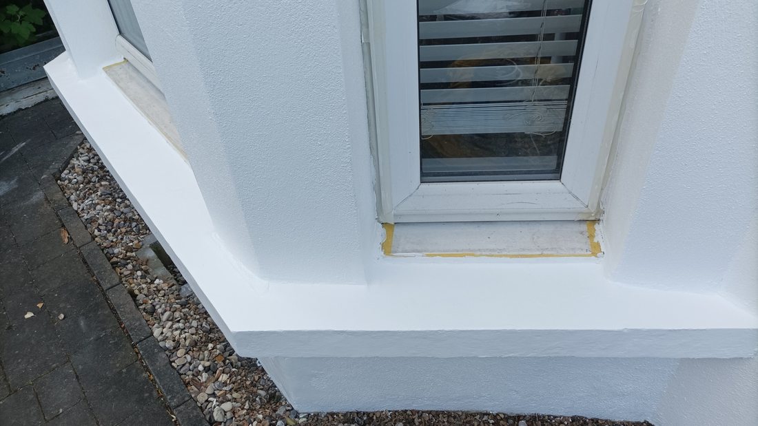 Window surround with fresh paint and masking tape